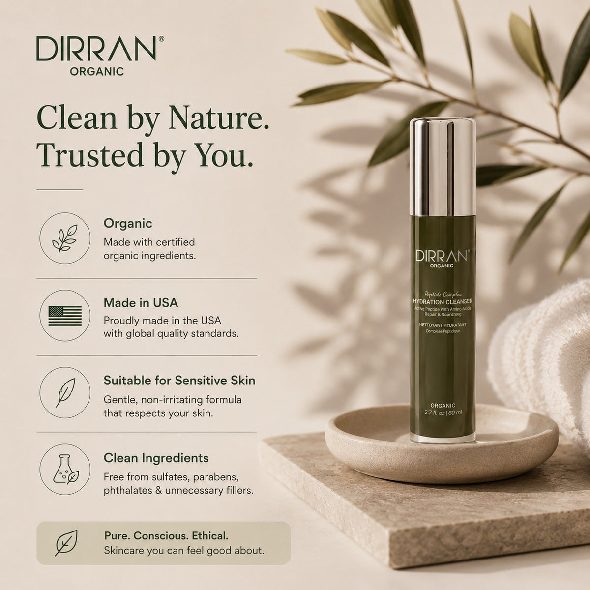 DIRRAN Organic Hyalu-Cleanse Hydration Cleanser bottle displayed on a stone tray next to a soft white towel, with decorative olive leaves in the background and product feature callouts on the left.